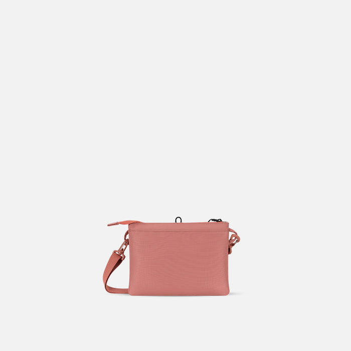 A Sherpani Zoom Desert Pink Slim RFID Crossbody, back view against white background. #color_desert-pink