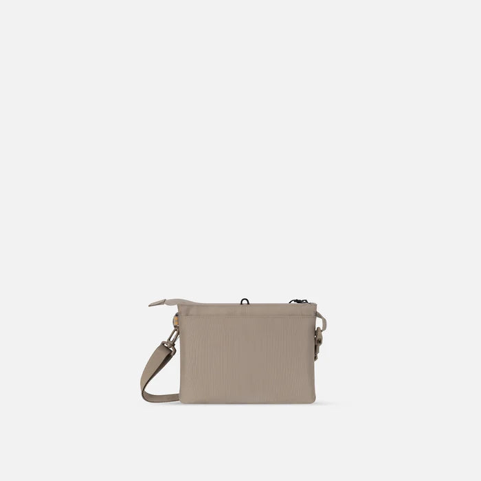A Sherpani Zoom Dune Slim RFID Crossbody, back view against white background.  #color_dune-tan