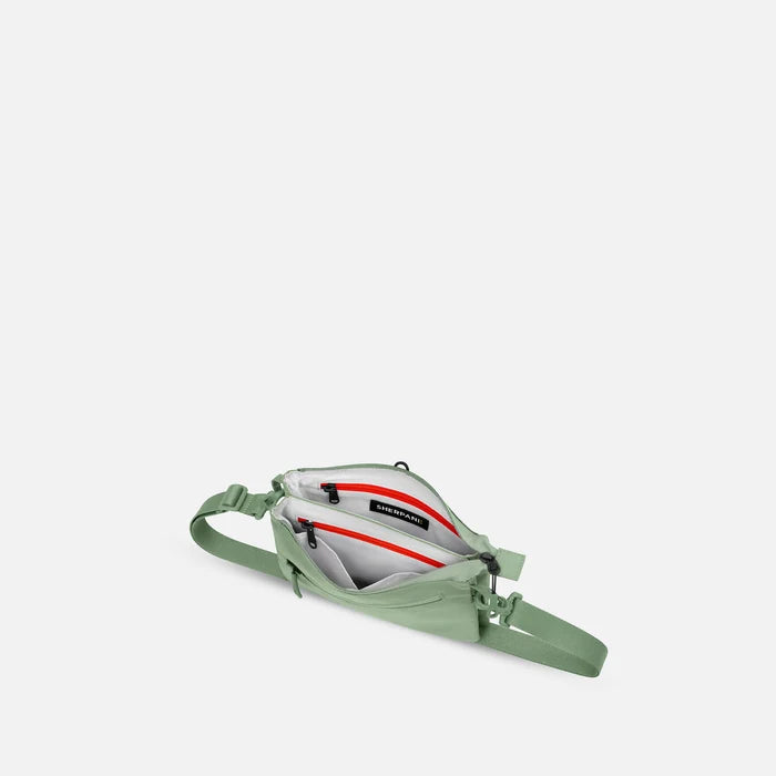 A Sherpani Zoom Olivine Slim RFID Crossbody, above view showing inside the two main pockets against white background. #color_olivine-green