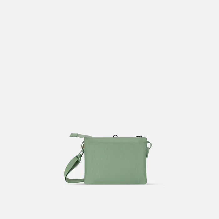 A Sherpani Zoom Olivine Slim RFID Crossbody, back view against white background.  #color_olivine-green