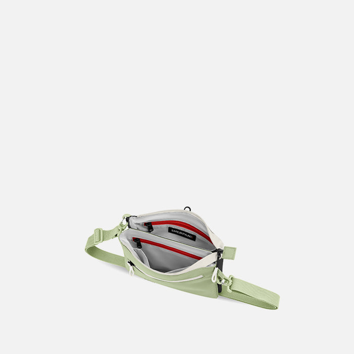 A Sherpani Zoom Palm Green Slim RFID Crossbody, above view showing inside the two main pockets against white background.  #color_palm-green