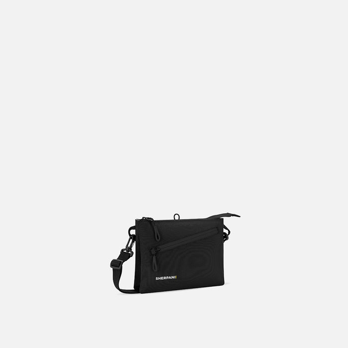 A Sherpani Zoom Raven Black Slim RFID Crossbody, 3/4 view showing lockable pocket and two main pockets on white background. #color_raven-black