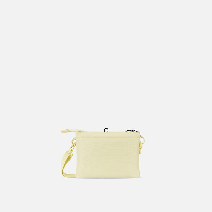 A Sherpani Zoom Sol Yellow Slim RFID Crossbody, back view against white background. #color_sol-yellow