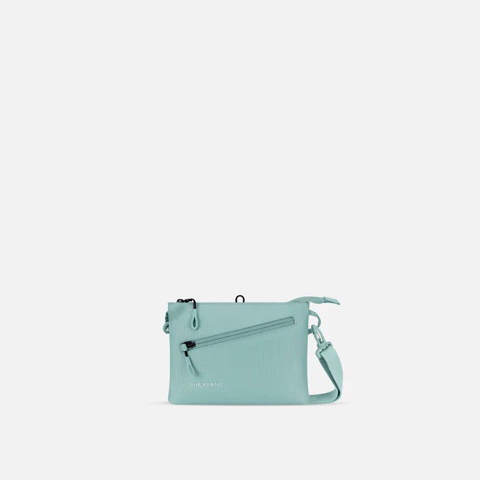 A Sherpani Zoom Surf Blue Slim RFID Crossbody, front view showing strap and pockets on white background.  #color_surf-blue