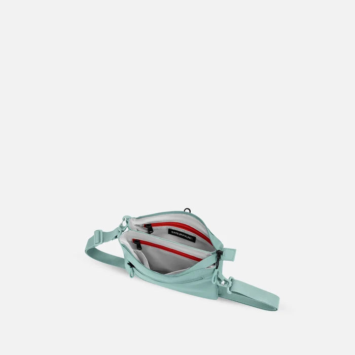 A Sherpani Zoom Surf Blue Slim RFID Crossbody, above view showing inside the two main pockets against white background.  #color_surf-blue