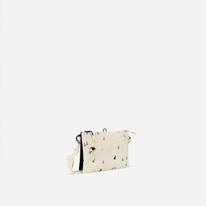 A Sherpani Zoom Terrazzo Print Slim RFID Crossbody, 3/4 view showing lockable pocket and two main pockets on white background. #color_terrazzo-print
